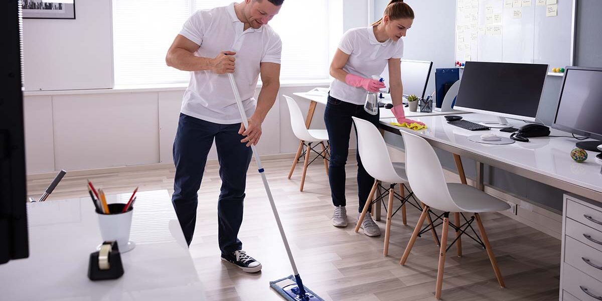 Smiling Two Young Janitor Cleaning The Office Profesjonalne mopy i systemy do mycia podłóg